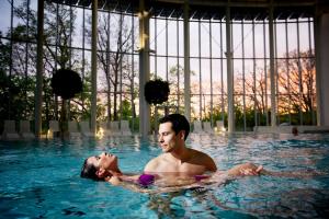 a man and a woman in a swimming pool at Luxury Spa Gîte - Loft Luxe in Spa