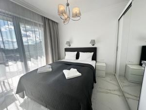 a bedroom with a bed with two towels on it at Promenada Gwiazd 14 by Baltic Home in Międzyzdroje