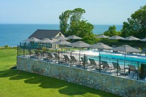 a swimming pool with chairs and umbrellas at Hotel Moraine in Greenport