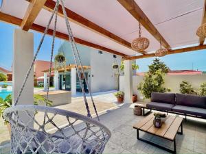 un patio al aire libre con un columpio y un sofá en Villa Cielo, en Sidari