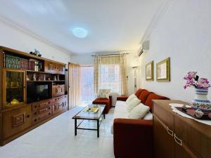 a living room with a couch and a tv at Ambient CostaBravaSi in Platja d'Aro