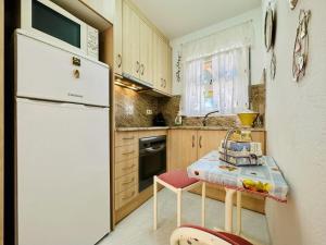 a kitchen with a white refrigerator and a table at Ambient CostaBravaSi in Platja d'Aro