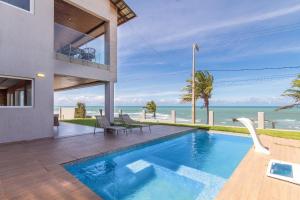a house with a swimming pool with a view of the ocean at Mansão Falésias #480 - Paraíso ao Mar da Praia de Sibaúma por Carpediem in Tibau do Sul