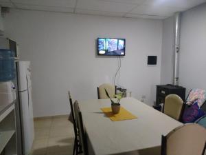 Habitación con mesa y TV en la pared. en Amor de Finca en General Alvear