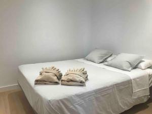a bed with white sheets and pillows on it at Apartamento Urban Recién reformado 15’ de la playa in San Vicente del Raspeig