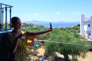 a woman holding a glass of wine on a balcony at Grand Suites with Private Pools in Kalamata