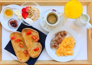a tray of food with bread and eggs and a cup of coffee at Pedras D'el Rei in Tavira