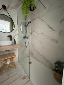a bathroom with a shower with a sink and a mirror at El rincón de Vejer. Vistas exclusivas y únicas. in Vejer de la Frontera