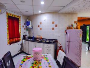 eine Küche mit Tisch und Kühlschrank in der Unterkunft Rajwada Farm Stay in Bhuj
