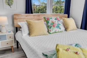 una camera da letto con letto, cuscini e finestra di Olive Studio Apart Unit 3 By Pmi a West Palm Beach
