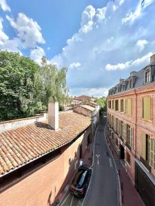 une voiture garée dans une rue entre deux bâtiments dans l'établissement Superbe duplex climatisé place St Etienne, parking, à Toulouse