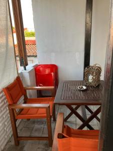 a table and chairs on a balcony with a table and a red suitcase at Erifyli in Nea Kallikrateia