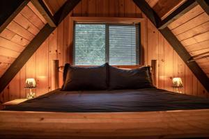 um quarto com uma cama grande num quarto com uma janela em Retro A-Frame Cabin - Firepit & Fireplace em Skykomish