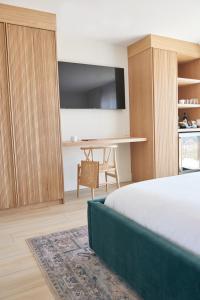 a bedroom with a bed and a desk with a television at Hotel Moraine in Greenport