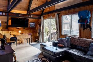 a living room with a couch and a tv and a desk at Retro A-Frame Cabin - Firepit & Fireplace in Skykomish