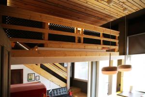 a loft bed in the living room of a house at Piccu Go in Pisogne