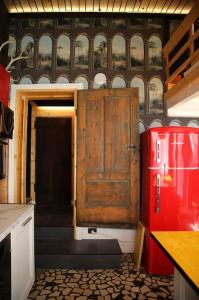 a kitchen with an old wooden door and a red refrigerator at Piccu Go in Pisogne