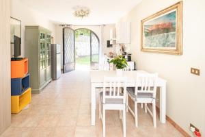 cocina y comedor con mesa blanca y sillas en Marco's Villa - Apartment with Private Pool, en Chiatri