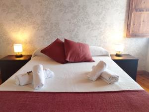 a bed with two towels on it with two lamps at Casa Aldea de Abaixo in Lugo