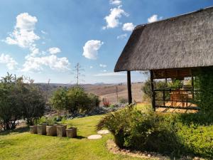 a farmhouse with a table and chairs in a yard at Sibani Lodge in Krugersdorp
