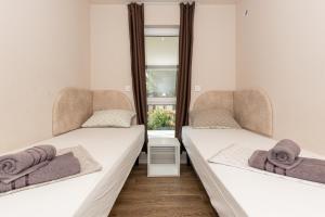 two beds in a room with two windows at Mobile House KASTANJOLA in Biograd na Moru