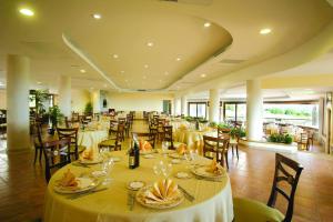 a dining room with tables and chairs and tablesktop at Hotel Santa Chiara in Capo Vaticano