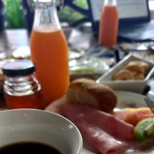 einen Tisch mit einem Teller Essen und einer Schüssel Orangensaft in der Unterkunft Casa Garay Hotel 658 in Asunción