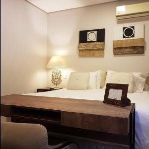ein Schlafzimmer mit einem Bett und einem Tisch mit einem Laptop darauf in der Unterkunft Casa Garay Hotel 658 in Asunción
