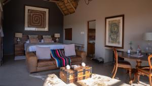 a living room with a bed and a couch and a table at Sibani Lodge in Krugersdorp