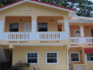 a large yellow house with a balcony at Hilltop View Guesthouse in Castries