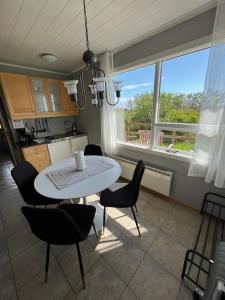 ein Esszimmer mit einem Tisch, Stühlen und einem Fenster in der Unterkunft Summer house - Fíflholt in Hvolsvöllur