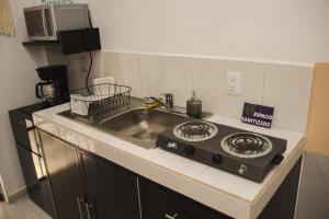 a kitchen with a sink and a stove at Departamento Orellana 5 in Chetumal