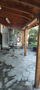 a patio with a stone floor and a wooden roof at Erifyli in Nea Kallikrateia