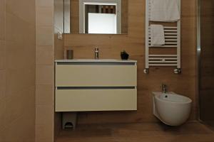 ein Badezimmer mit einem Waschbecken, einem Spiegel und einem WC in der Unterkunft CivicoDieci in Locorotondo