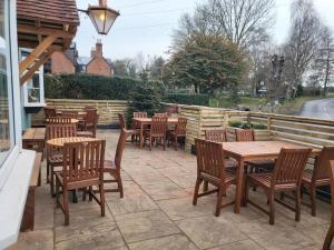 a group of tables and chairs on a patio at Three Horseshoes, Bubbenhall in Bubbenhall
