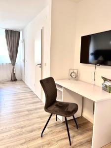 a white desk with a chair in a room at Sophie Flair Apartment in Karlsruhe
