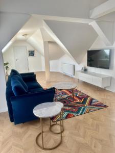 ein Wohnzimmer mit einem blauen Sofa und einem Tisch in der Unterkunft Apartmány Harmony Liptov in Liptovský Mikuláš