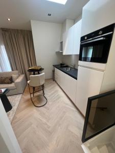 una cocina con armarios blancos y una mesa en una habitación en Centrum Hilversum appartement en Hilversum