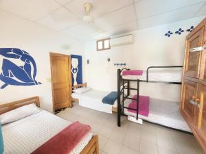 a room with three bunk beds in it at Divanga Hostel in Taganga