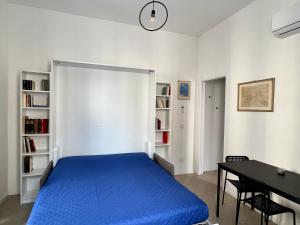 a bedroom with a blue bed and a desk at Casa Genova 1/2/3 in Turin