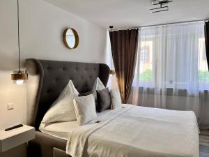 a bedroom with a white bed with a window at Prime Host Flair Apartment in Karlsruhe