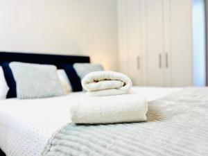 a stack of towels sitting on top of a bed at Modern Apartment at Temple Bar with River View in Dublin