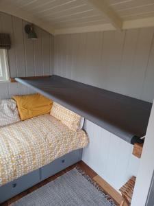 a room with a couch in a small room at The Old Post Office - Luxurious Shepherds Hut 'Far From the Madding Crowd' based in rural Dorset. in Todber