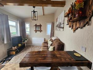 a living room with a wooden table and a couch at Beautiful & Stunning 1-Bed Chalet in Bridlington in Bridlington