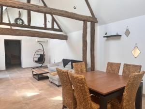 a dining room with a table and chairs and a couch at Gîte du ptit château 