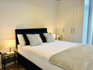 a bedroom with a large bed with two pillows at Modern Apartment at Temple Bar with River View in Dublin