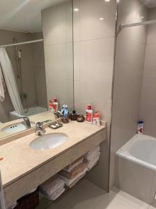 y baño con lavabo y espejo. en Puerto Madero Apartment Free Parking 2 lots 2 bdr 140m2 1,500 sq ft 3 Pools Gym and full amenities Opening February 2023 sophisticated furniture, en Buenos Aires