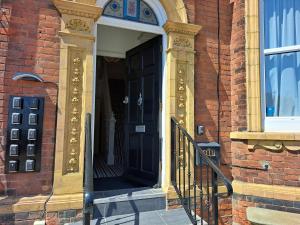 uma entrada para um edifício de tijolos com uma porta preta em Annabelle Rooms em Great Yarmouth