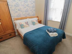 a bedroom with a bed with a blue blanket at The Old School House in Scarborough