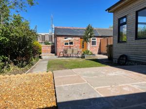 a brick house with a patio and a yard at The Old Station House by Holiday Heim in Lytham St Annes